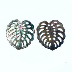 A heart-shaped black mother of pearl bead with a leaf pattern design, with a mix of dark and light brown colors.