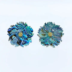 Pair of blue flower-shaped earrings on a light blue background