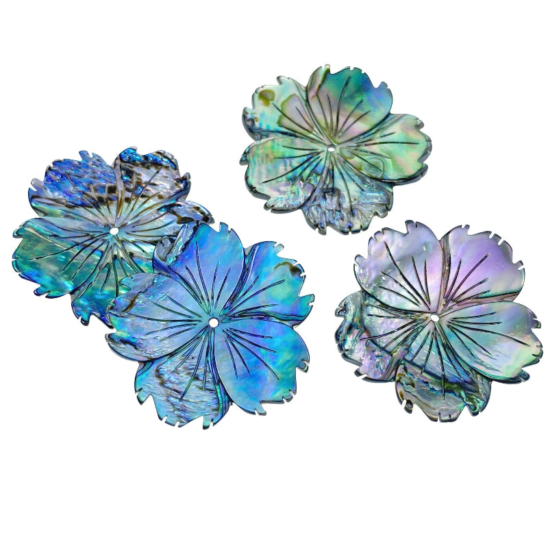 A hand-carved abalone shell flower bead with a natural color pattern resembling a hibiscus flower.